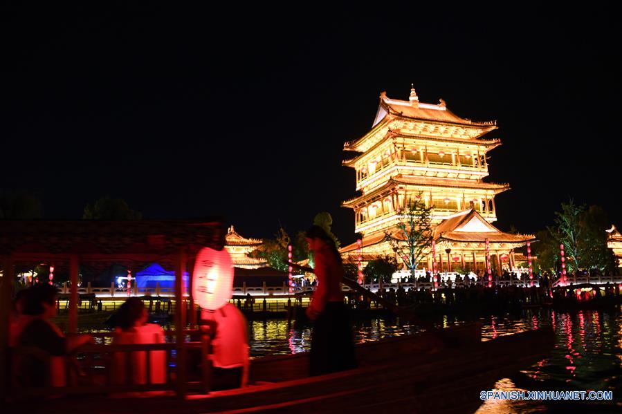 Turistas toman botes turísticos de noche en la zona escénica del antiguo pueblo de Taierzhuang